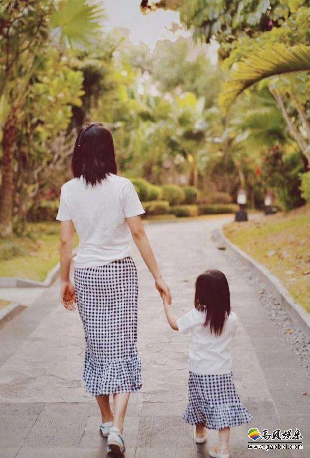朱丹晒出与女儿散步背影照，她和女儿穿着同款亲子装，手牵手走在花园里