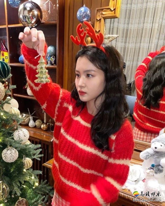 李夏怡近日在SNS发布她装点圣诞树照片，一副圣诞节风格打扮喜庆又温暖